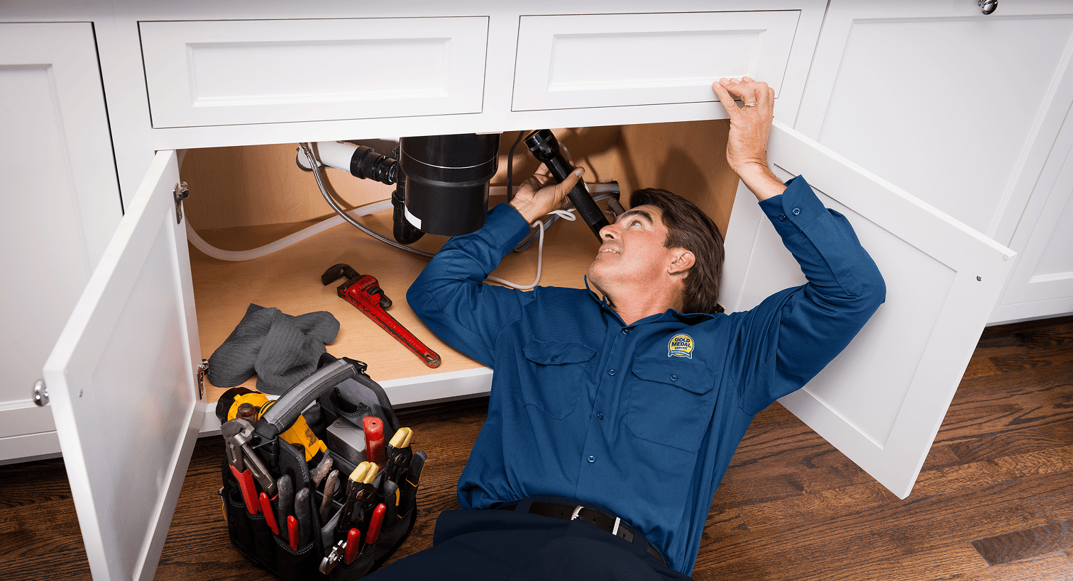 Man working under a kitchen sink