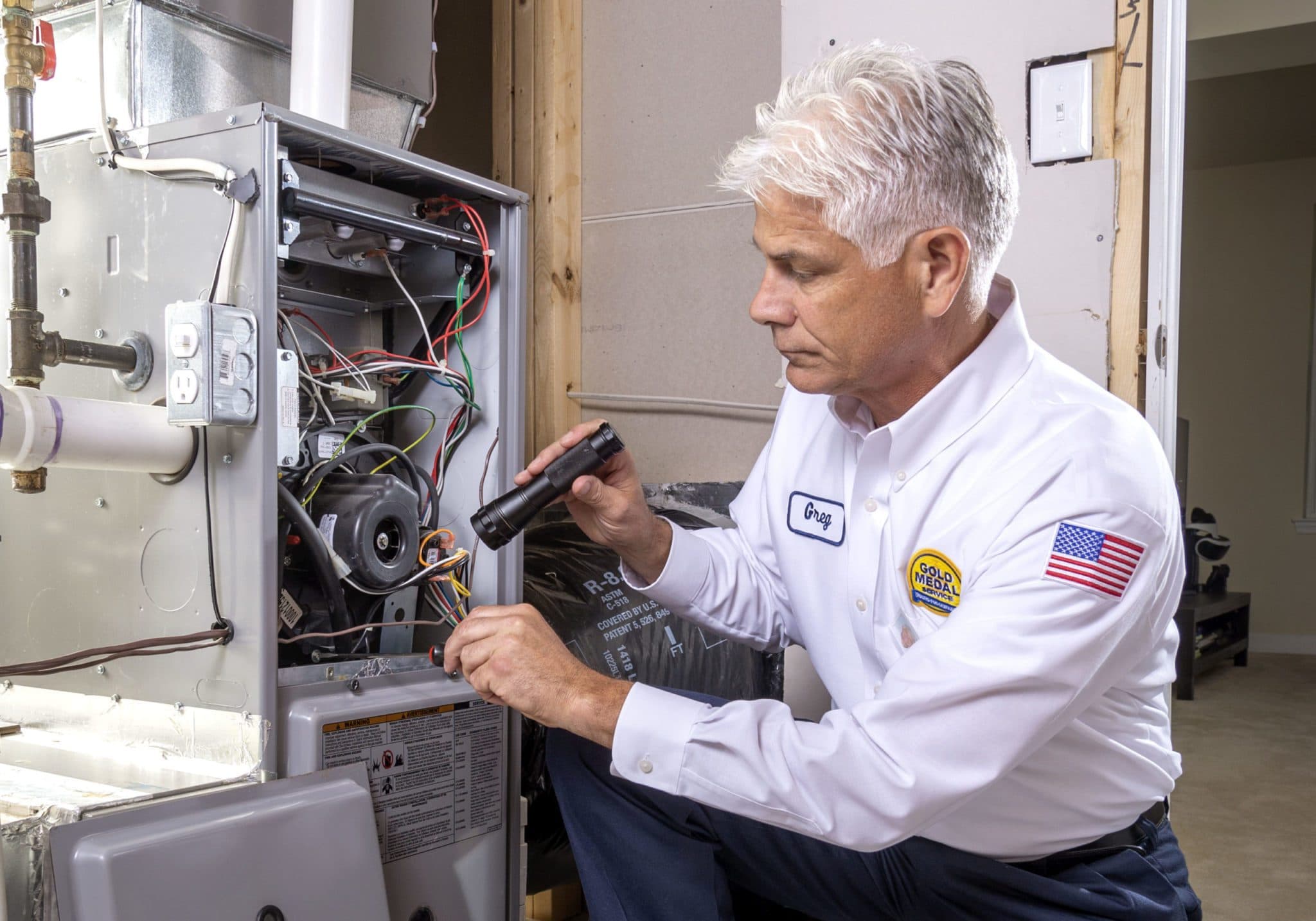 A Gold Medal technician is performing a heater tune up