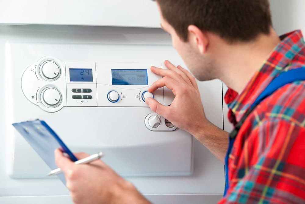 A man adjusts a knobs after boiler repairs