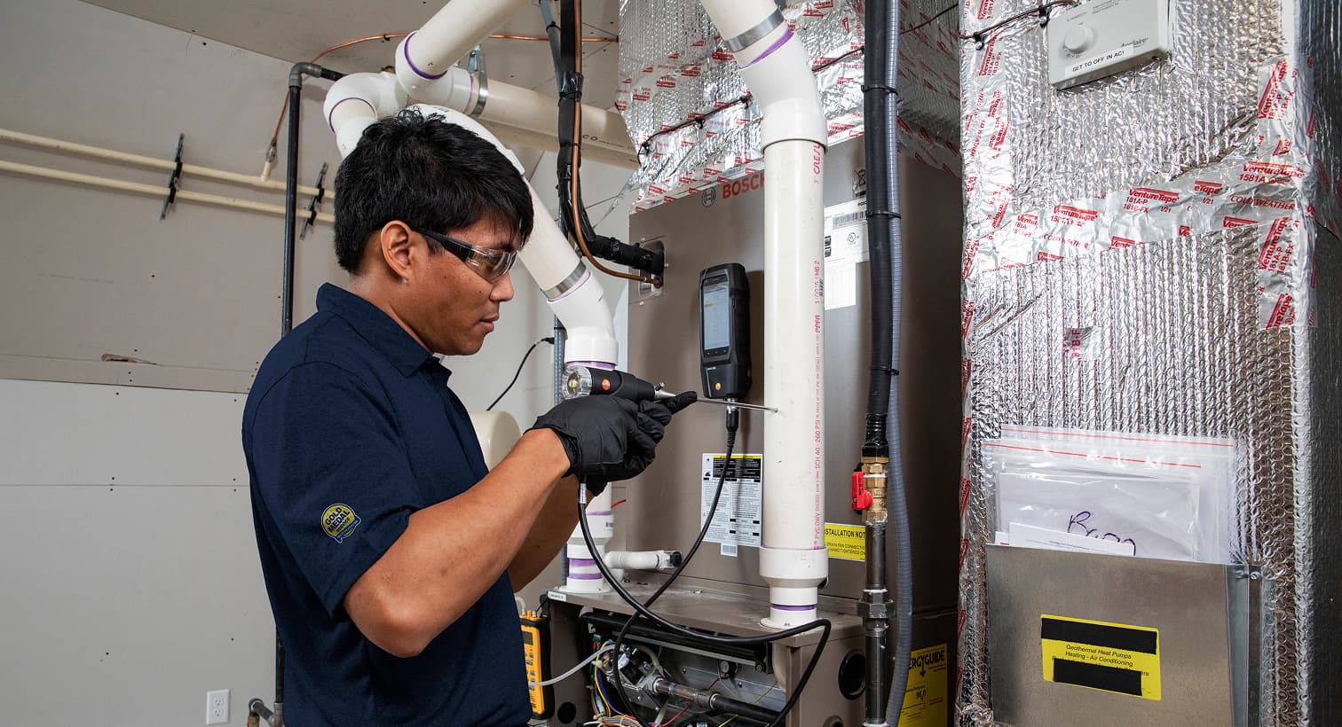 A Gold Medal technician working on a heating and cooling system