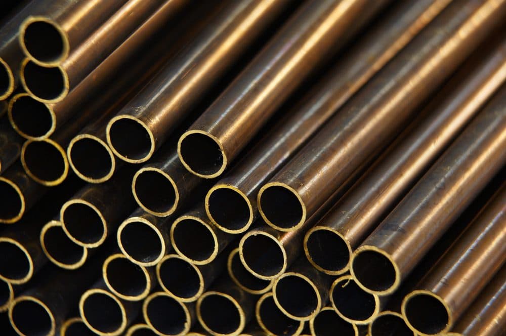 A stacked pile of brass plumbing pipes