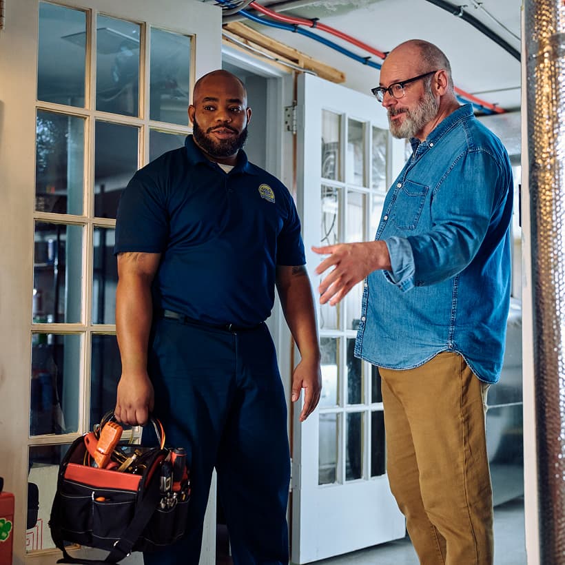 A Gold Medal technician discusses the repair and installation services with a homeowner.