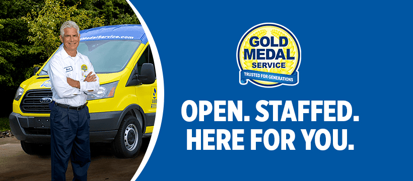 A smiling Gold Medal technician in front of his van with text saying open, staffed and here for you underneath a Gold Medal logo