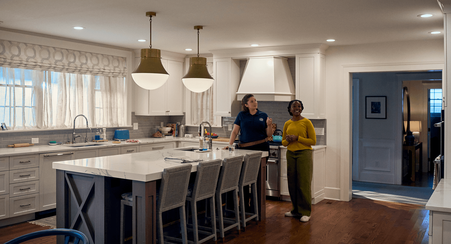 A homeowner and a Gold Medal technician talk in her dining room