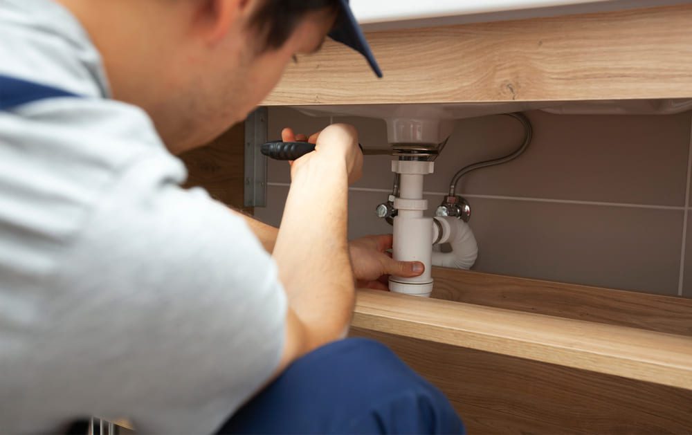 residential plumber fixing a sink